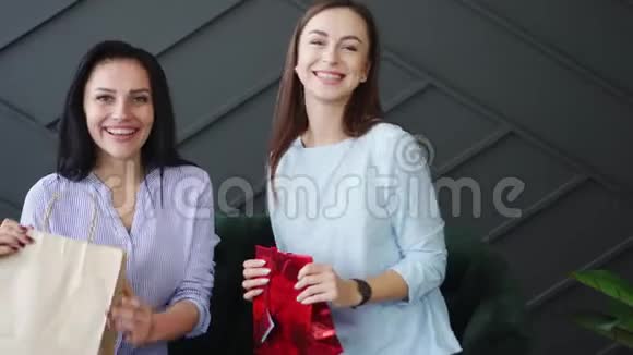 两个幸福的女朋友手里拿着购物袋竖起大拇指视频的预览图