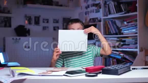 一个小学生手里拿着一张白纸把它卷起来视频的预览图