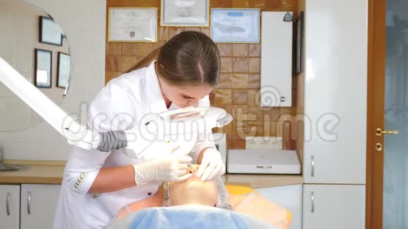 整容的概念医学美容中心的妇女接受嘴唇增强手术戴手套的美容师美容视频的预览图