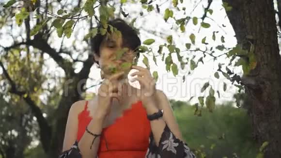 白种人女孩短发在阳光下触摸树早午餐的肖像欣赏日落的女人视频的预览图