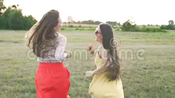 两名年轻的女游客在暑假穿着裙子在公园散步视频的预览图