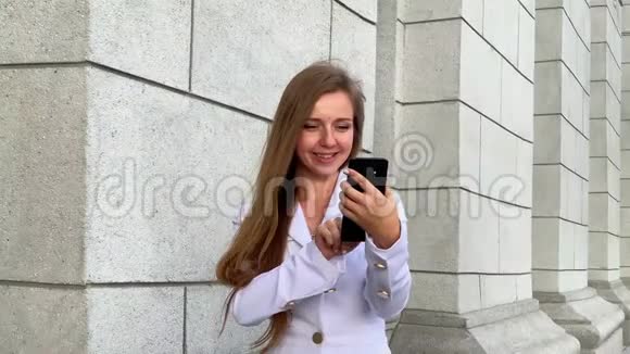 在智能手机上浏览的年轻商务女性笑容满面笑容可掬视频的预览图