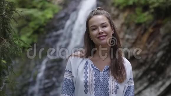 一幅年轻女子的肖像她的脸上有雀斑看着瀑布前面的相机女孩花时间视频的预览图