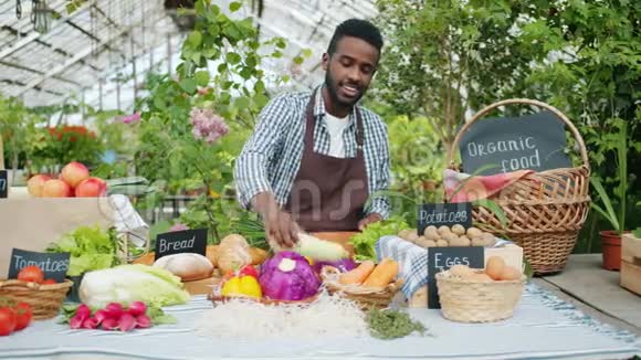 非裔美国推销员把新鲜的有机蔬菜摆在餐桌上进行农场销售视频的预览图
