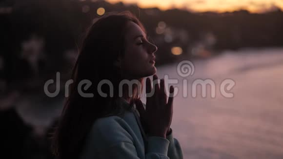 近距离描绘美丽的女人享受宁静的日落探索灵性仰望祈祷沉思视频的预览图