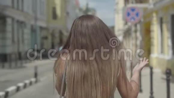 自信的年轻女子在欧洲老城走来走去打电话挥动手臂快乐女孩的休闲视频的预览图