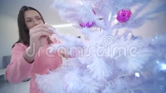 年轻的女性设置人造圣诞树树枝和视频的预览图