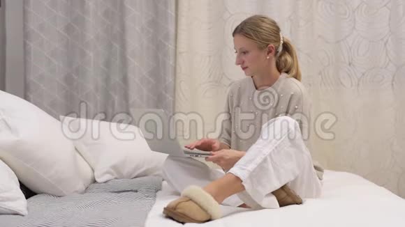 漂亮的女人正在床上用电脑打字视频的预览图