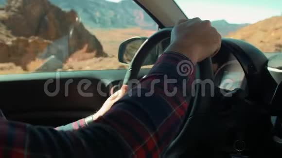 不认识的人穿着格子衬衫开车在火山岛的沙漠外山脉和石崖视频的预览图
