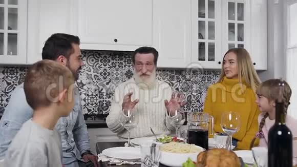 有魅力的男人女人和他们的孩子的家庭受人尊敬的祖父坐在感恩节的桌子旁视频的预览图