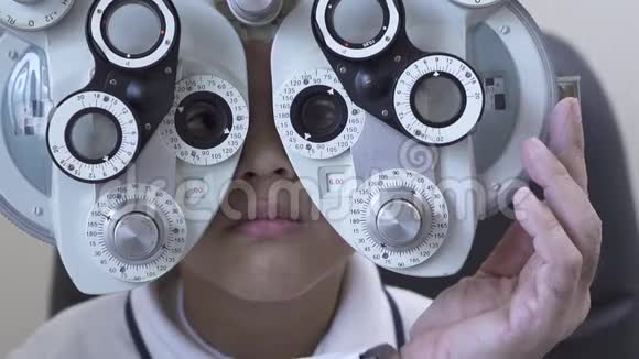 小男孩眼科医生用光翅目近距离检查眼睛医生换玻璃的手视频的预览图