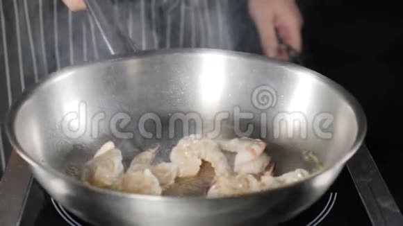 餐厅厨房常规慢动作快关门厨师的手移动和翻锅与大虾深度油炸视频的预览图