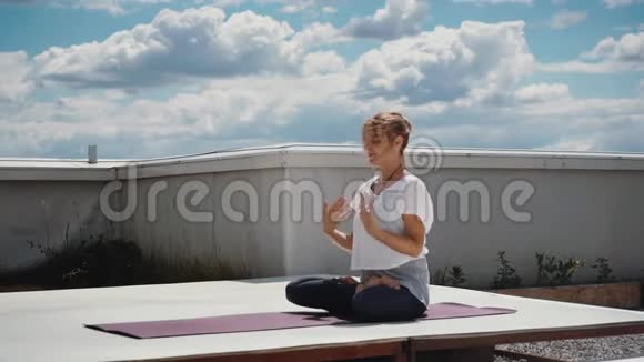 年轻女子在瑜伽垫上练习高级瑜伽体式视频的预览图