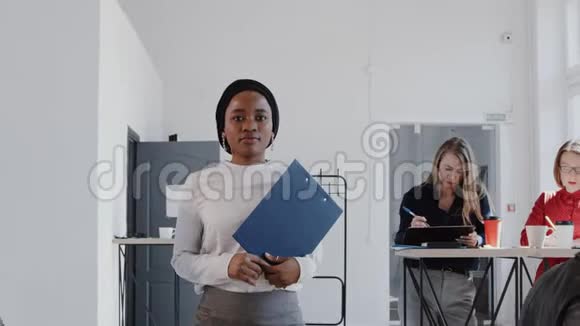 快乐美丽成功的黑人商务女性走在现代办公室看相机慢动作红色EPIC视频的预览图