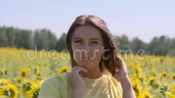 美丽的女人站在田野里向日葵视频的预览图