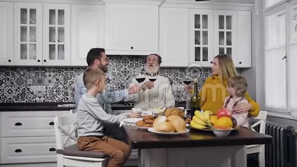欢笑的一家人坐在餐桌旁举杯庆祝感恩节视频的预览图