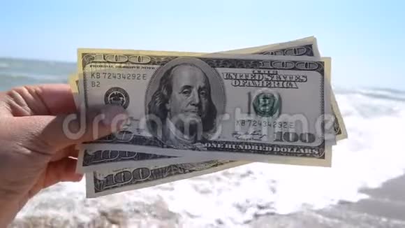 大海背景下300美元钞票的女孩视频的预览图