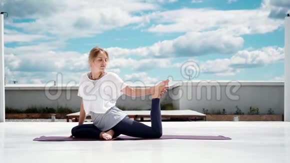 做瑜伽运动的年轻女性一条腿一只鸽子慢动作视频的预览图