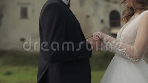 白人新郎和新娘靠近古堡墙新婚夫妇新婚快乐视频的预览图