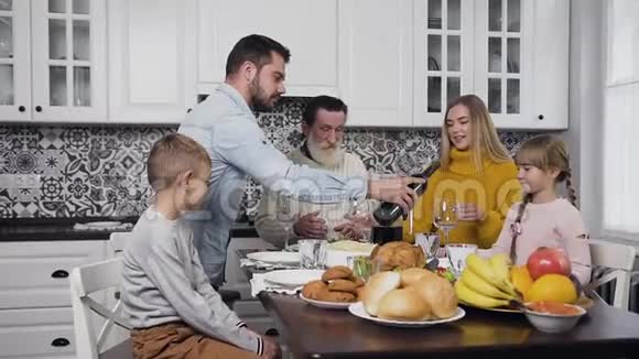 喜结良缘的一家人在节日的餐桌上聚在一起庆祝感恩节而有魅力的男人则蜂拥而至视频的预览图