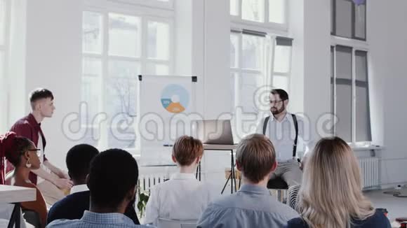 年轻熟练的商人教练在现代轻办公室研讨会上给小观众演讲红色EPIC慢动作视频的预览图