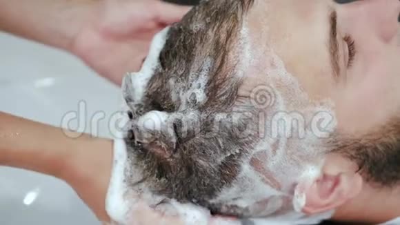 美容院理发师用洗发水清洗客户头部视频的预览图