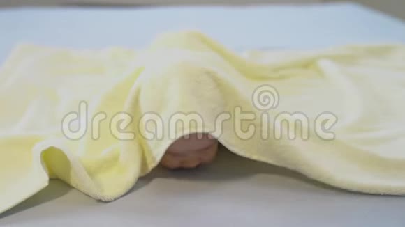 可爱的小男孩带着黄色毛巾在家玩视频的预览图