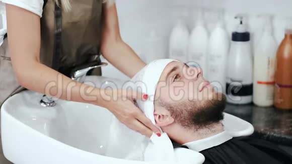 美容师用白色毛巾擦拭客户头部视频的预览图