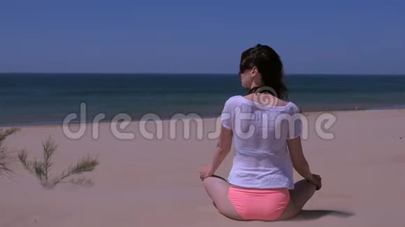 少女冥想坐莲姿瑜伽沙滩望海后景视频的预览图