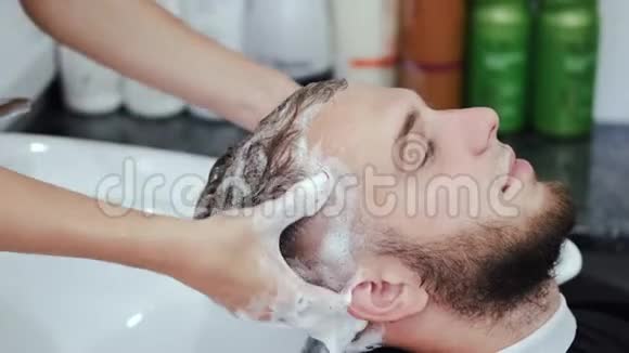 美容院理发师用洗发水清洗客户头部视频的预览图