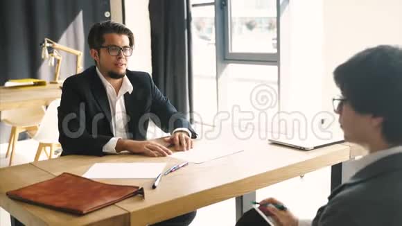两个人在办公室的办公桌上进行商务讨论视频的预览图