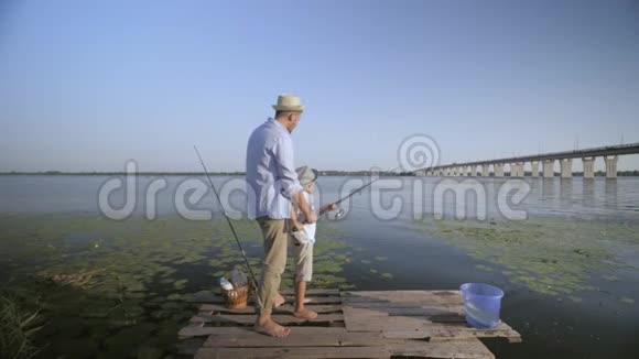 父亲是一位热心的父亲年轻的父母一家人在河边教他心爱的小渔夫的手艺视频的预览图