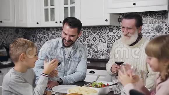 欢笑快乐的爸爸和爷爷和可爱的男孩和女孩在感恩节坐在桌子旁视频的预览图