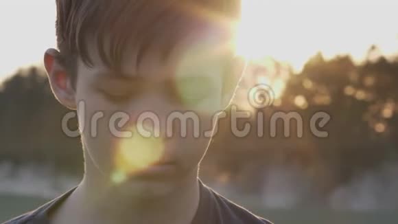一个男孩的肖像在日落时落下闭上眼睛视频的预览图