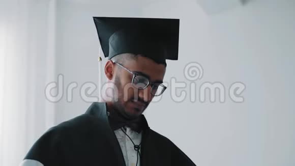特写印度学院毕业生穿着文凭看着他视频的预览图