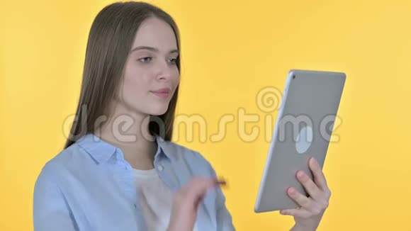 青年妇女桌上的视频聊天黄色背景视频的预览图