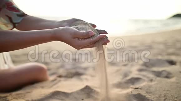 女人拿着沙子放在海滩上暑假旅行和娱乐视频的预览图