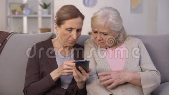 两位成熟的女士试图处理智能手机技术问题视频的预览图