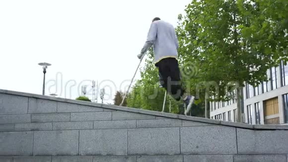 一条腿拄着拐杖的人在街上做翻转动作残疾人培训和做戏法积极主动视频的预览图