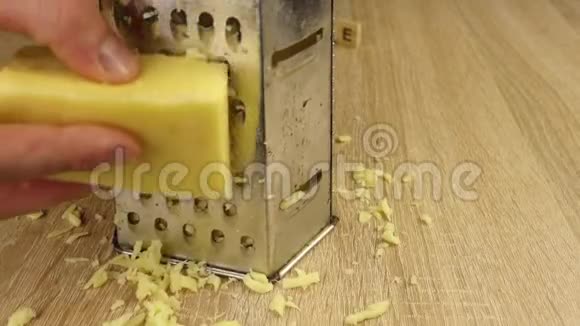 男人把奶酪篦在金属烤架上视频的预览图