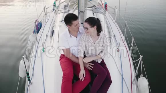 幸福的一对拥抱在海上的帆船上视频的预览图