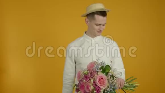 戴着帽子拿着花束微笑的年轻人视频的预览图