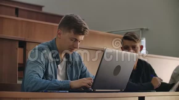 大学或学院的学生用笔记本电脑写讲座在研究所毕业视频的预览图