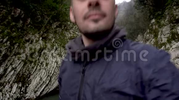 男人在俄罗斯索契的峡谷魔鬼之门自拍和显示拇指视频的预览图