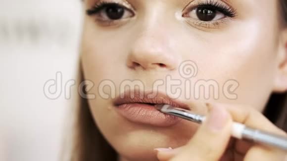 化妆师在沙龙用画笔描唇的特写视频的预览图
