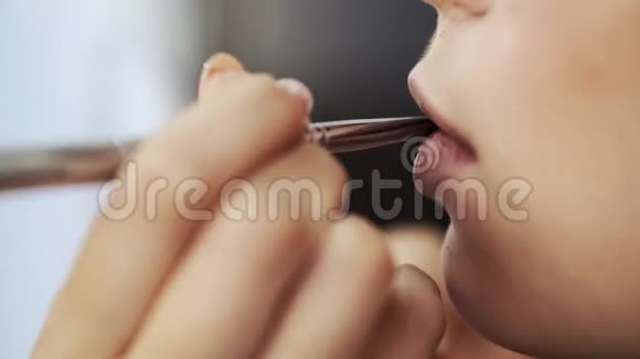 化妆师在沙龙用画笔描唇的特写视频的预览图