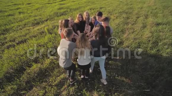 一群友好的朋友在日落时在田野里扔糖果视频的预览图