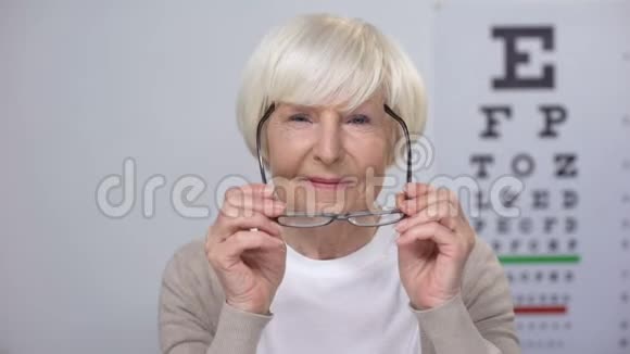 快乐的女性退休者戴上新眼镜寻找凸轮改进视频的预览图