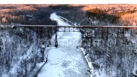明尼苏达州冰冻河上的冬季铁路桥视频的预览图