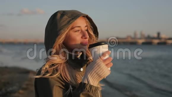 在秋日的河边喝茶的女人视频的预览图